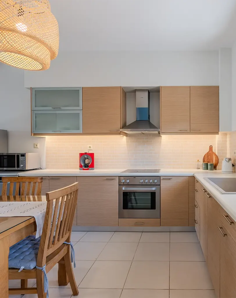 A woman setting tables in a restaurant, arranging chairs and placing utensils for upcoming diners.